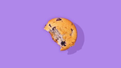 Bitten blueberry muffin isolated on a purple background