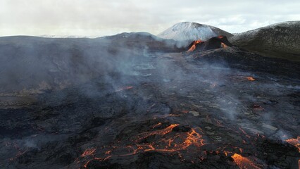 Volcanic eruption with glowing orange lava flow surrounded by a pool of bubbling magma