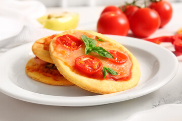 Plate with different tasty mini pizzas on white background