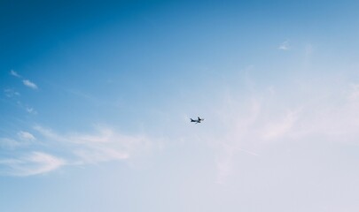 Low angle shot of a plane flying in a blue sky