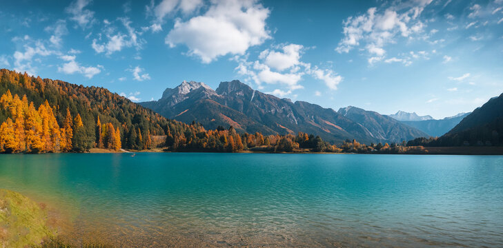 beautiful fairytale landscape in autumn with mountains in the background and a blue lake