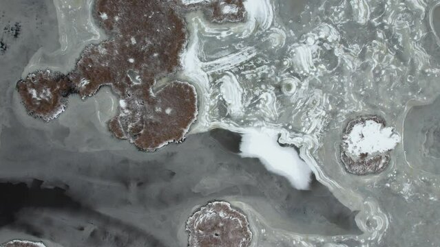 Aerial of abstract reed islands on a frozen lake in Latvia.