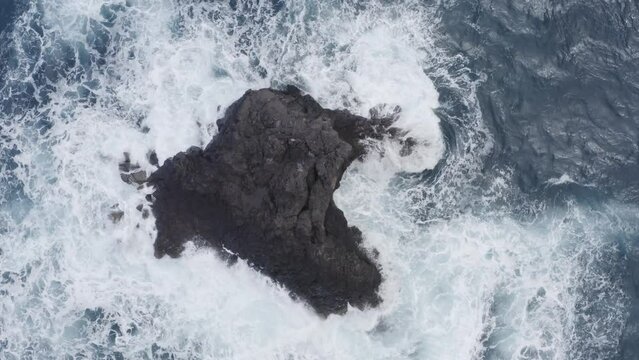 Aerial of sea waves crashing the rock in Madeira island.