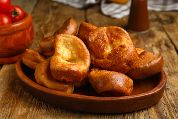 Plate with tasty Yorkshire pudding on wooden background