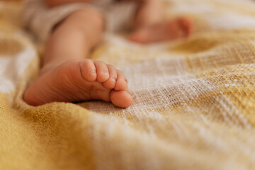 children's bare feet on the bed on a yellow blanket