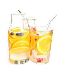 Glass and bottles of infused water with orange slices on white background