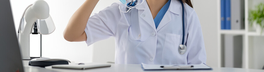 beautiful woman in a doctor's suit with gloves and mask in a doctor's office