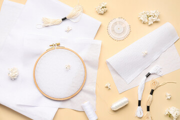 Wooden embroidery hoop with canvases and ball pins on pale orange background © Pixel-Shot