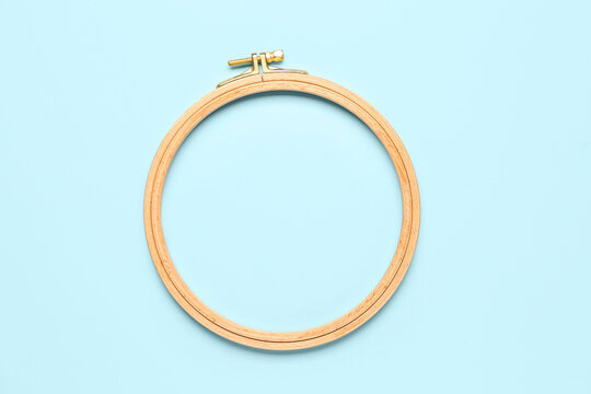 Wooden embroidery hoop on blue background