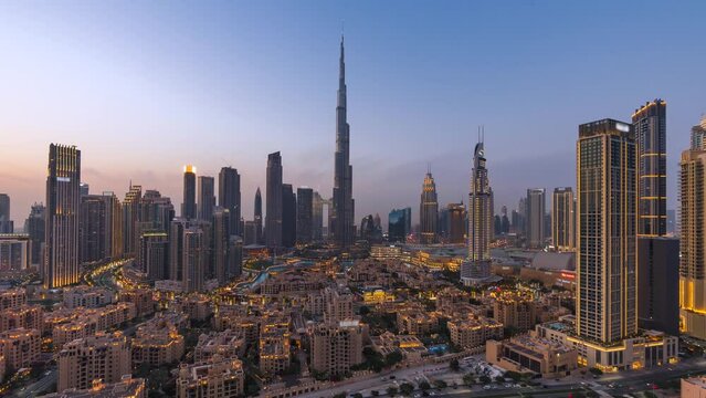 Day to night timelapse view of skyscrapers and traffic in Downtown Dubai, United Arab Emirates (UAE), business and finance concept, modern cities and skylines, zoom out.