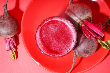 Plate with glass of healthy beet juice on red background - obrazy, fototapety, plakaty