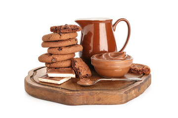 Wooden board with cookies, chocolate and jug of milk on white background