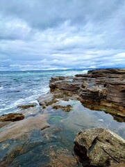 Beautiful view of rocky sea with waves under the cloudy sky