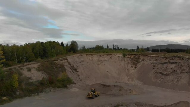 Aerial video of a stone quarry and a crusher surrounded by trees on a cloudy day
