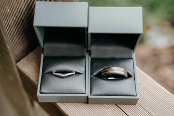 Closeup shot of gray boxes with bride and groom engagement rings