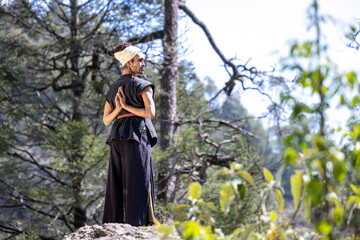 young, attractive, dark-skinned mexican latino man with bohemian style, hipster, doing yoga outdoors.