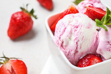Square bowl of strawberry ice cream with mint and berries on white grunge  table