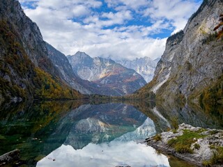 Fototapeta na wymiar Landscape view of Obersee Lake in Germany under rocky mountains and blue cloudy sky