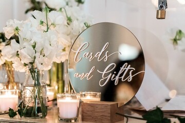 Closeup of a wedding decoration with flowers, candles and a mirror with a writing 