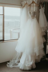 Fototapeta na wymiar Hanging wedding dress in room