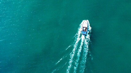 Aerial view of the ship driving on the blue sea with copy space