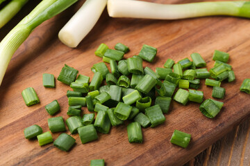 Board with slices of fresh green onion, closeup