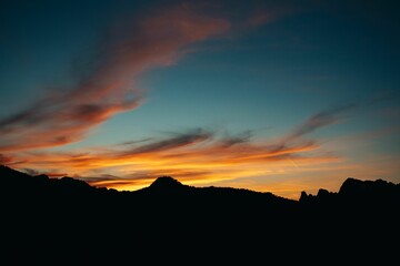 Scenic shot of sunset over the silhouettes of hills