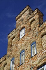 Fototapeta premium View of a stepped roof building with a brick wall and small windows
