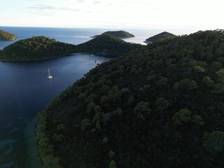 Scenic bird's eye view of boats sailing in the tranquil sea in an evergreen island