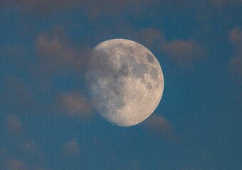 Mesmerizing view of the moon in a blue sky with clouds