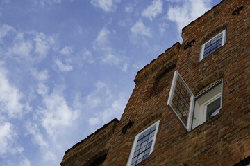 View of a stepped roof building with a brick wall and small windows