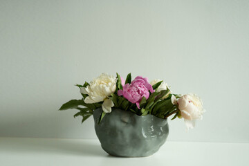 White and Pink peonies in a handmade vase. Beautiful peony flower for catalog or online store. Floral shop concept . Beautiful fresh cut bouquet. Flowers delivery. Copy space