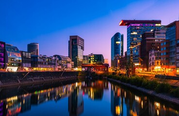 Skyline of Dusseldorf harbor at dusk reflected in the water