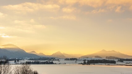 Scenic view of calm coast and mountainous islands during sunset