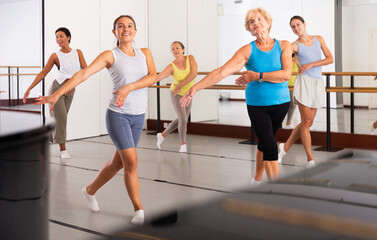 Fototapeta na wymiar Energetic women performing modern dance in fitness studio