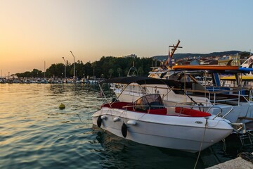 Fototapeta premium Scenic view of boats docked by the pier seen during sunset