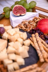 Vertical closeup shot of a fig, walnuts, and sliced cheese as appetizers