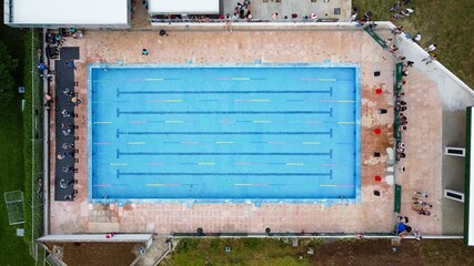 Top view of participants ready to jump in a clear blue pool