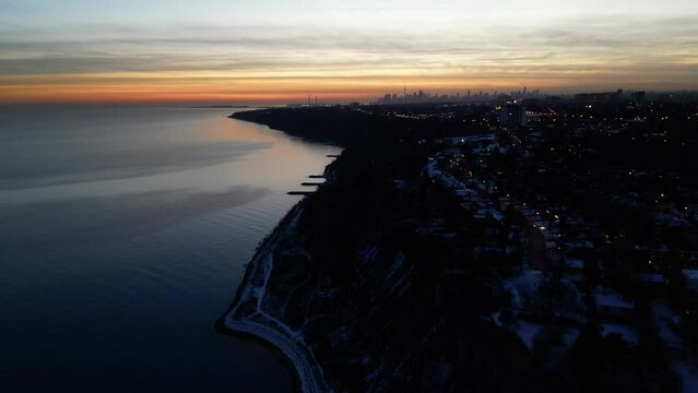 Aerial shot of a coastal city on a hgh cliff at dusk