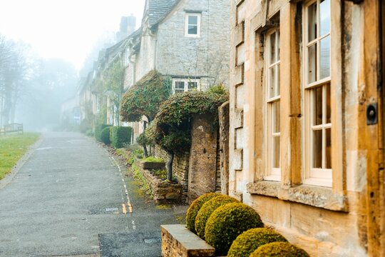Beautiful shot of old houses along a narrow street on a foggy day in Burford, Cotswolds, Oxfordshire