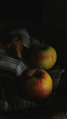 Closeup of juicy red and green apples wrapped in a striped cotton towel