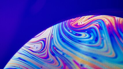Closeup of a colorful object with bubbles on a violet background