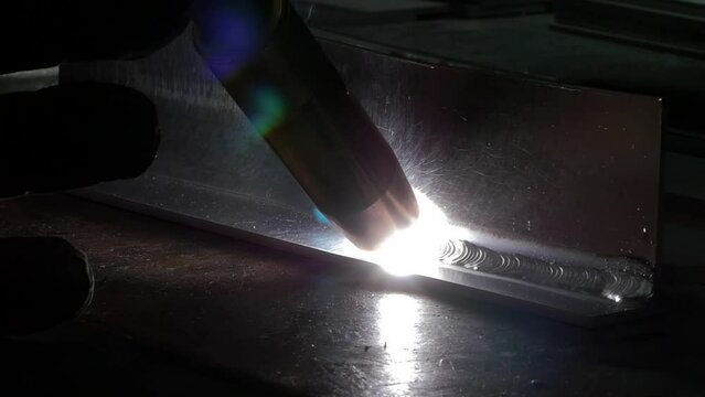 Closeup of a welding tool in circular design motion on a metal, reflecting white light
