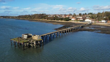 Fototapeta na wymiar Drone shot of a wooden dock near the shore of a sea