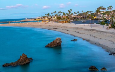 Aerial shot of a coastal resort town and pieces of rocky in the blue sea in summer