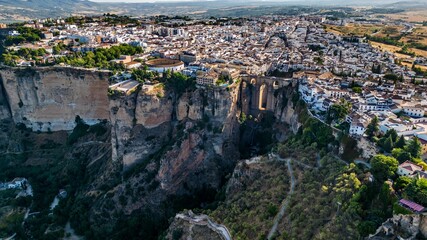 Fototapeta na wymiar Drone shot of buildings and houses on the edge of a rock in Ronda, Spain