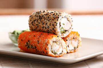 Plate with tasty sushi rolls  on table, closeup