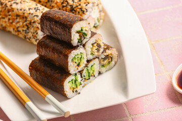 Plate with delicious sushi rolls on table, closeup