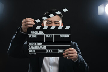 Asian actor with clapperboard on stage. Film industry - obrazy, fototapety, plakaty