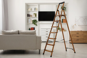 Wooden folding ladder in stylish living room